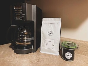 A coffee maker, a coffee bag, and a jar of coffee. - Bunkhouse Barndominium (Eureka Springs)