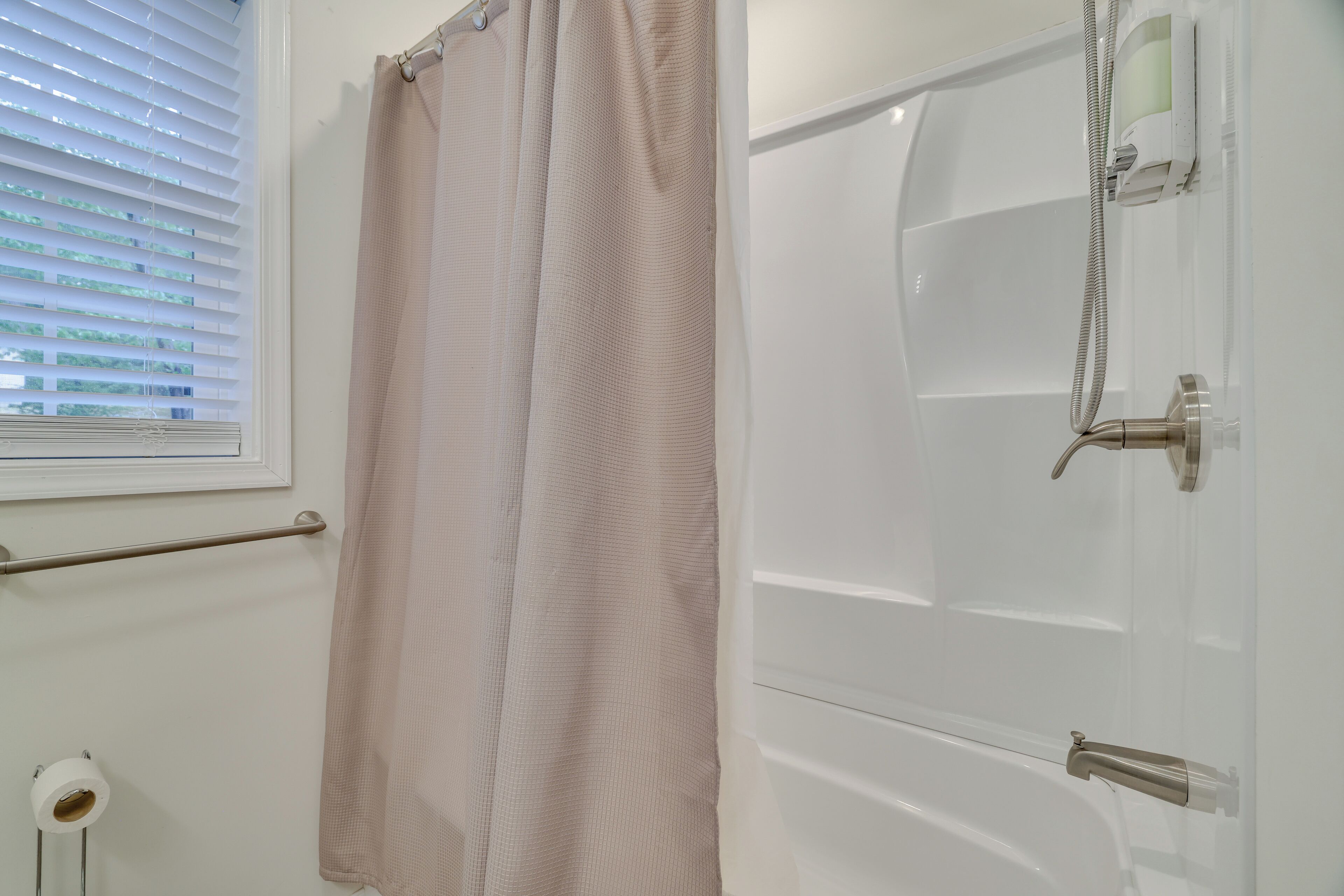 Un baño con ducha, toallero y retrete.