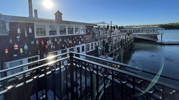 A waterfront building with a dock extending into the water, featuring a sign for 'Eagle's Nest Cocktails' and a 'Lobsters' section. - Steps to Restaurants, Shops & Waterfront, Bar Island, Free 2-car Parking,  Wi-fi (Bar Harbor)