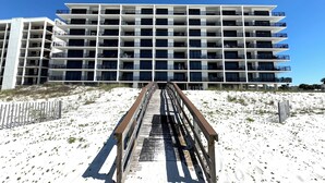 Un hotel de varios pisos con balcones y un paseo de madera que lo lleva a él.