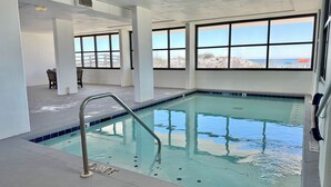 Una piscina interior con amplias ventanas que ofrecen vistas despejadas al exterior.