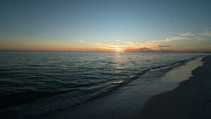 A beach scene with a calm sea and a clear sky.