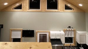 Une cuisine avec un plafond en bois, un ventilateur de plafond et une fenêtre au-dessus de l’évier.