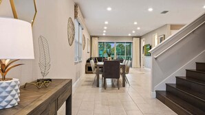 Un intérieur moderne comprenant un coin repas, un escalier et une vue sur l’extérieur.