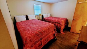 A small, single-bedroom room with two beds, a wooden wardrobe, and a window with blinds. - Sunsplash 5, walk to beach, walk to Main Street (North Myrtle Beach)