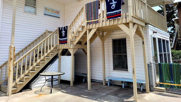 A two-story building with a balcony, a staircase, and a small table. - Sunsplash 5, walk to beach, walk to Main Street (North Myrtle Beach)
