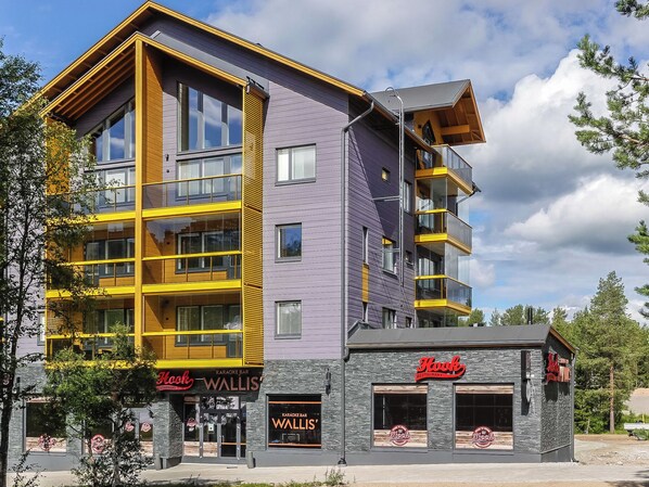 Un immeuble à plusieurs étages qui abrite un bar karaoké appelé « Wallis » et un restaurant appelé « Hook ».