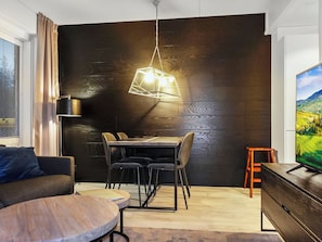 A modern living room with a dining area, a sofa, a TV, and a wooden wall. - Levin kunkku dome c5 by Interhome (Kittilä)