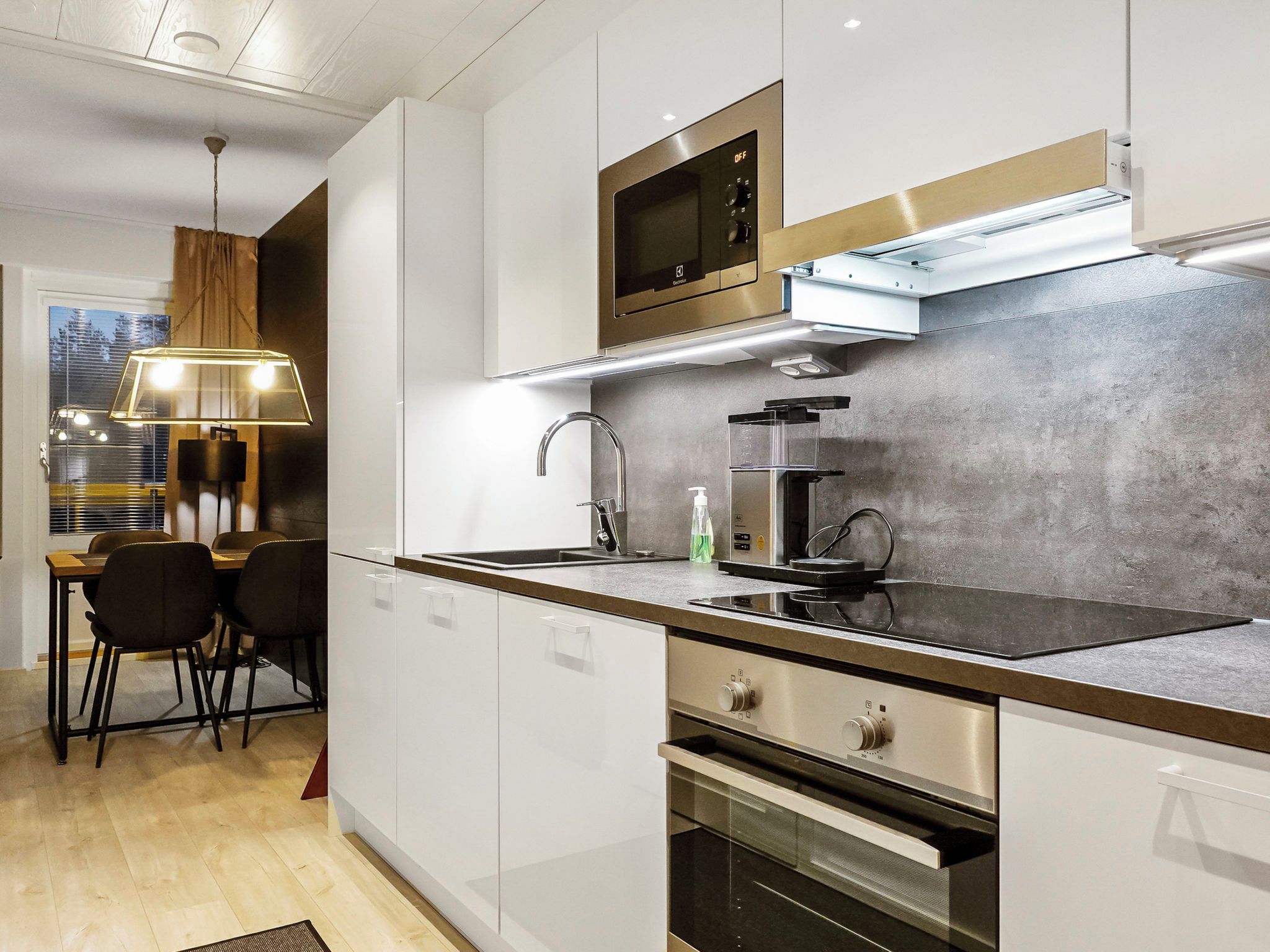 A modern kitchen with a built-in oven, a microwave, and a coffee maker.