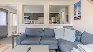 A modern living room with a grey sofa, a coffee table, and a remote control.