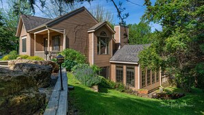 A two-story house with a front porch, a chimney, and a small attached garage. - Bright and peaceful Galena retreat. Near amenities and Chestnut (Galena)