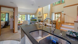 A spacious kitchen with a large island, a built-in stove, and a dining area with wooden chairs and a table. - Bright and peaceful Galena retreat. Near amenities and Chestnut (Galena)
