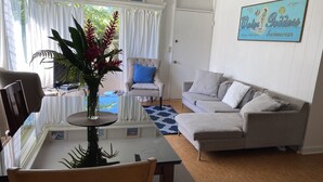 Sala de estar com uma mesa de jantar, um sofá e um ventilador de teto.
