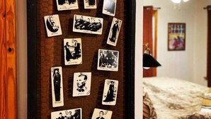 A wall with a collection of black and white photographs arranged in a grid pattern. - The Hideaway at Bear Mountain Log Cabins (Eureka Springs)