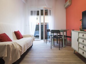 A bedroom with a bed, a table with chairs, and a TV on a cabinet. - San José. Appartement avec garage (Toledo)