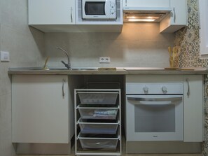 A kitchenette with a microwave, oven, and sink. - San José. Appartement avec garage (Toledo)