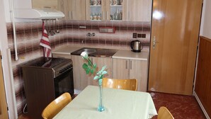 Une cuisine de taille réduite, équipée d’une cuisinière, d’un évier et de placards.