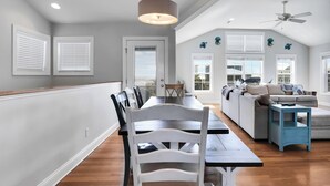 Un espacio habitable moderno con comedor, sofá y ventilador de techo.