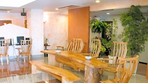 A conference room with a long wooden table, several chairs, and a few potted plants. - Deigo Hotel (Okinawa)