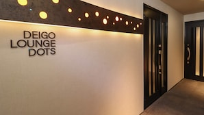 A hallway with a sign reading "DEIGO LOUNGE DOTS" and a door with a modern design. - Deigo Hotel (Okinawa)