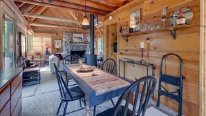 Ein gemütliches Blockhaus-Interieur mit Essbereich, Kamin und Holzwänden.