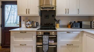 Een koelkast, een magnetron, een oven, kookgerei, borden en bestek