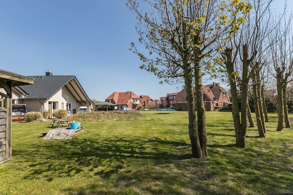 Un quartier résidentiel avec des maisons, une pelouse verdoyante et une terrasse en bois.