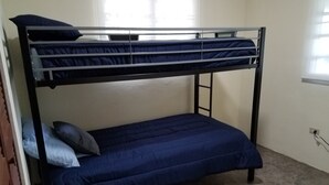 A bunk bed with a lower bunk and a mattress on the floor.