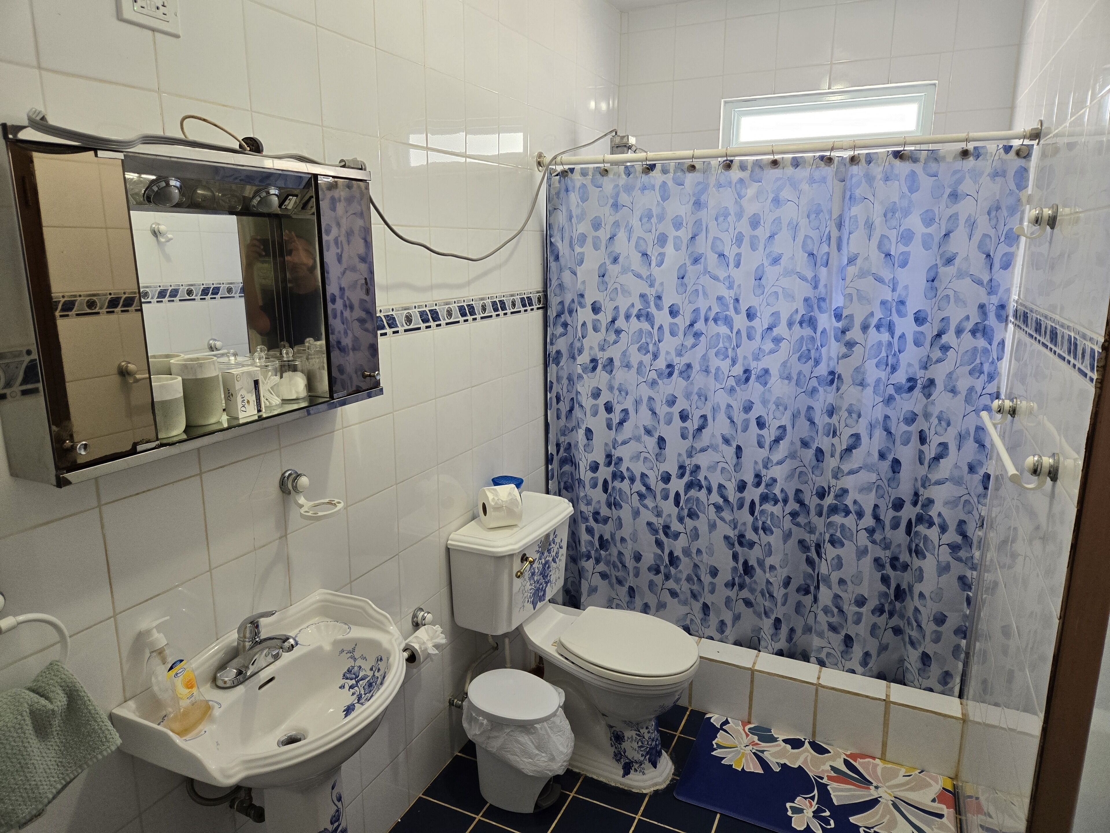 A bathroom with a sink, toilet, and shower curtain.