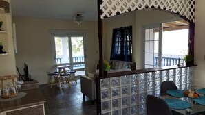 A dining area with a glass partition, a table with blue placemats, and a view of the outdoors.