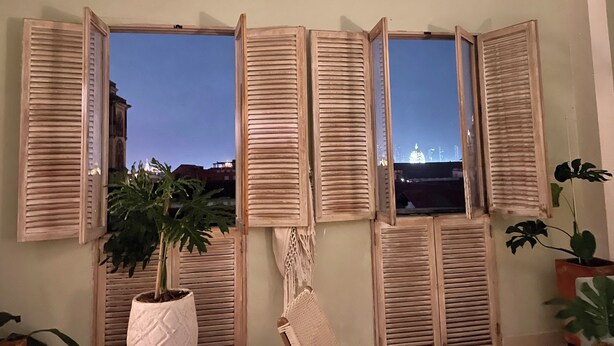 A room with a view of a cityscape through a set of wooden shutters. - Tropicalia is a Charming Studio in the middle of the Old City of Cartagena. (Cartagena)