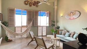 A living room with a hammock, wicker chairs, a sofa, a coffee table, and a TV. - Tropicalia is a Charming Studio in the middle of the Old City of Cartagena. (Cartagena)
