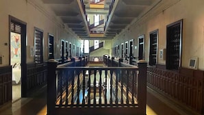 A long corridor with a central railing, multiple doors, and a staircase leading to an upper level. - Tropicalia is a Charming Studio in the middle of the Old City of Cartagena. (Cartagena)