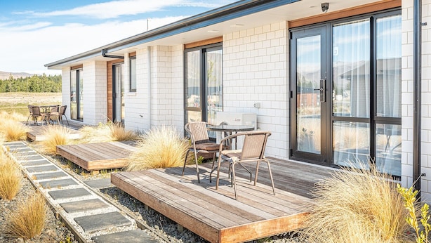 A modern house with a patio area featuring outdoor furniture and a view of the surrounding landscape. - Star View - 1 Bedroom suite C (Lake Tekapo)