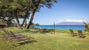 A grassy area with metal lounge chairs and a view of the ocean. - Aston Maui Kaanapali Villas 262 | Tropical Garden Views – Pool, Hot Tub & Spa (Lahaina)