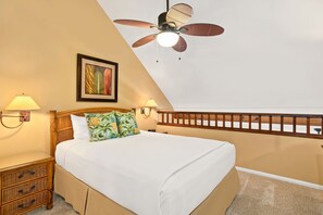 A bedroom with a bed, a ceiling fan, a nightstand, a lamp, and a framed picture on the wall. - Aston Maui Kaanapali Villas 262 | Tropical Garden Views – Pool, Hot Tub & Spa (Lahaina)