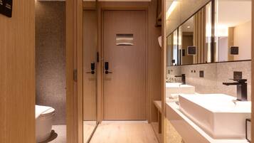 Un bagno moderno con porte in legno, un water e due lavabi con specchi.