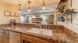 A kitchen with granite countertops, stainless steel appliances, pendant lighting, and a built-in oven. - Walk to Ski, Near Canyon Lodge, Quiet Getaway 512 (Mammoth Lakes)