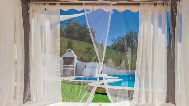 Una tenda con vista su una piscina e un'area barbecue.