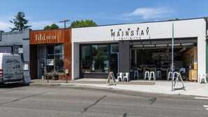 Un escaparate con un letrero que dice "MAINSTAY PROVISIONS" y una entrada visible.