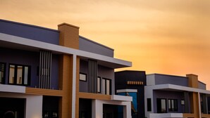 A modern multi-story building with a flat roof and a mix of wood and concrete materials.
