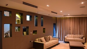 A modern living room with two sofas, a coffee table, and a wall with built-in shelves.