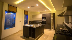 A modern kitchen with a central island, built-in appliances, and a large window with a city view.