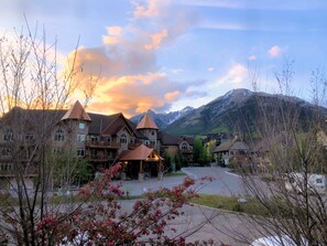 A lodge with multiple buildings, a central building with a red roof, and a mountainous backdrop.