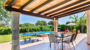 Une terrasse extérieure équipée d’une table de billard, de chaises et d’une table pour les repas.