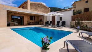 A swimming pool with lounge chairs and a covered seating area. - Holiday Home Can Tianet with Mountain View, Pool, Wi-Fi & Terrace (Randa)