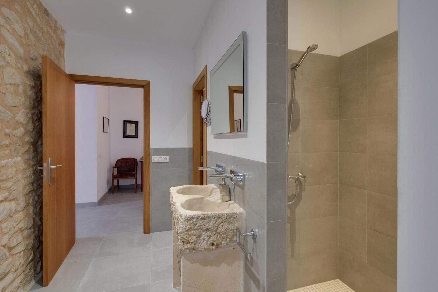Un baño con un lavabo de piedra, ducha y espejo.