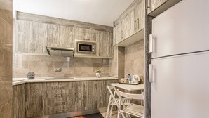 A compact kitchen with a built-in microwave, a sink, and a refrigerator.
