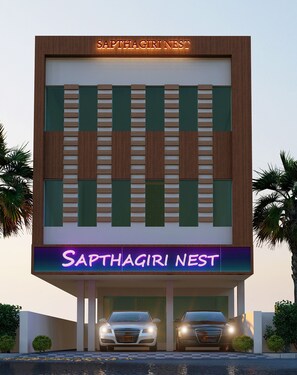 A building with a sign reading "Saphagiri Nest" and two cars parked in front. - Hotel Sapthagiri Nest (Coimbatore)