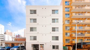 Un edifici de diversos pisos amb façana plana, diverses finestres i una màquina expenedora a la planta baixa.